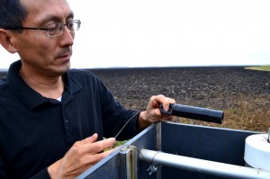Dongqing Lin inspects monitoring equipment at ND Clay Co. Farm